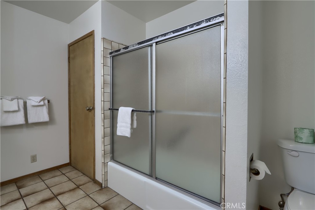 8041 Chilnualna Falls Road Wawona, CA 95389 - Photo 16 of 46 a bathroom with a glass shower door