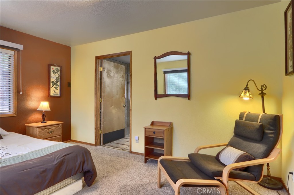 8041 Chilnualna Falls Road Wawona, CA 95389 - Photo 22 of 46 a bedroom with a bed and chair