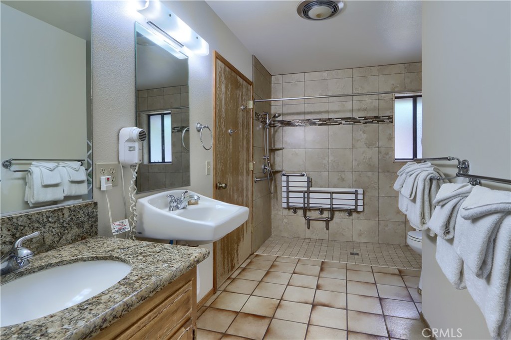 8041 Chilnualna Falls Road Wawona, CA 95389 - Photo 24 of 46 a bathroom with a granite countertop sink a mirror and shower