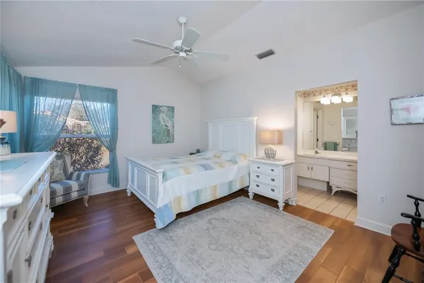 a spacious bedroom with a bed and a wooden floor