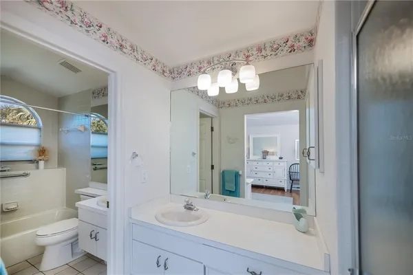 a bathroom with a sink vanity granite and a toilet