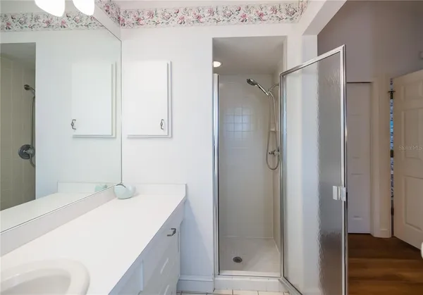a bathroom with a shower sink and mirror