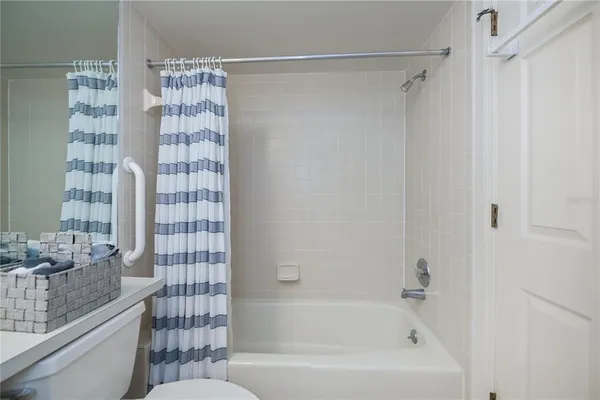 a bathroom with a granite countertop bathtub shower sink and toilet