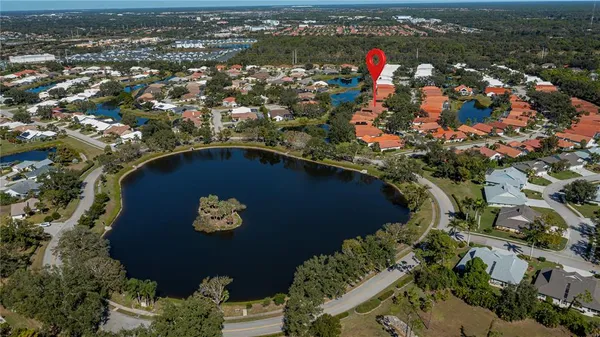 an aerial view of a house with a yard and lake view in back