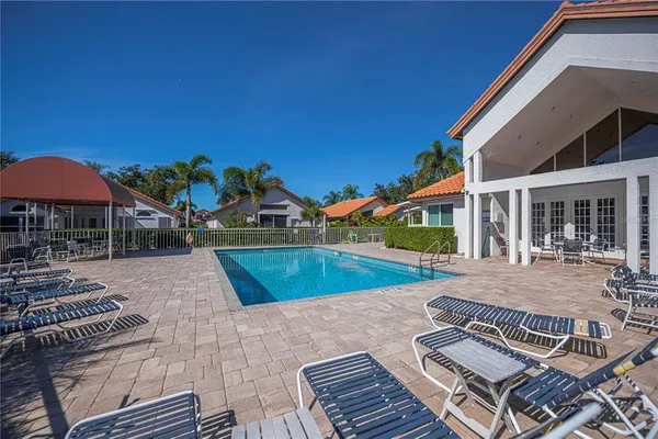 a view of a house with pool and chairs