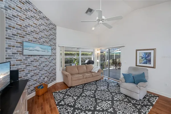 a living room with patio furniture and a floor to ceiling window