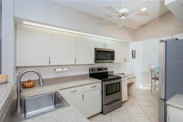 a kitchen with stainless steel appliances granite countertop a sink a stove and refrigerator