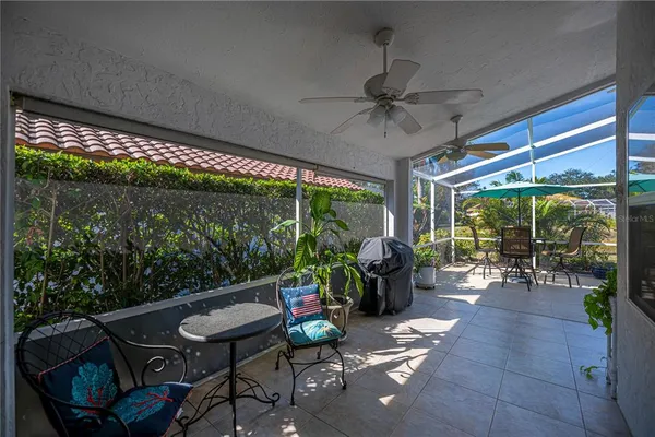 a living room with patio furniture and a floor to ceiling window