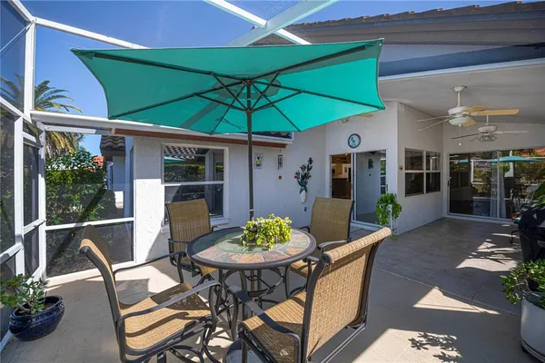a patio with a table and chairs under an umbrella