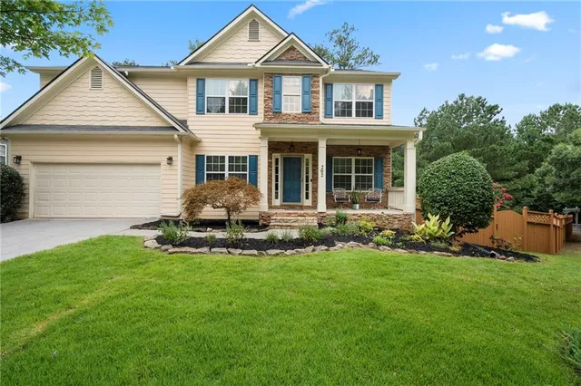 a front view of a house with a garden and yard