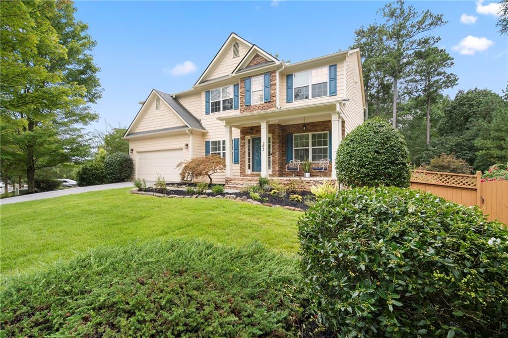 202 Reserve Crossing Canton, GA 30115 - Photo 2 of 56 a front view of a house with a garden and trees