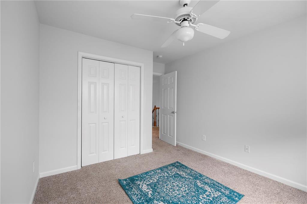 202 Reserve Crossing Canton, GA 30115 - Photo 29 of 56 an empty room with a ceiling fan and a rug