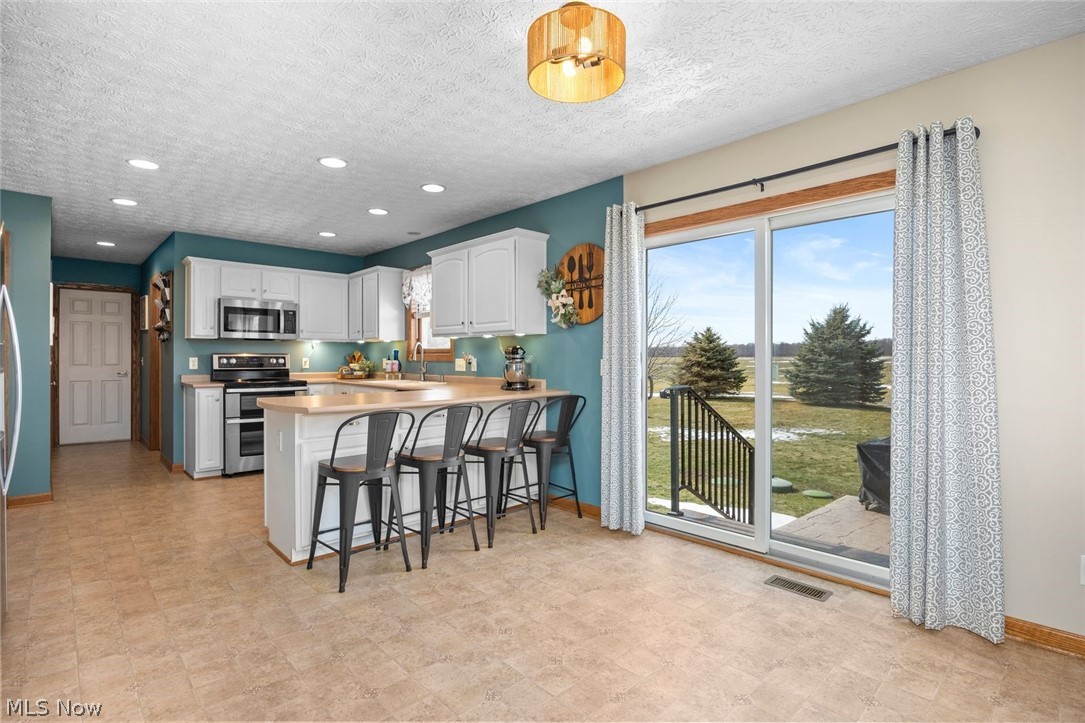 4273 Old State Road Willard, OH 44890 - Photo 6 of 50 Kitchen featuring light countertops, stainless steel appliances, a peninsula, a breakfast bar, and recessed lighting