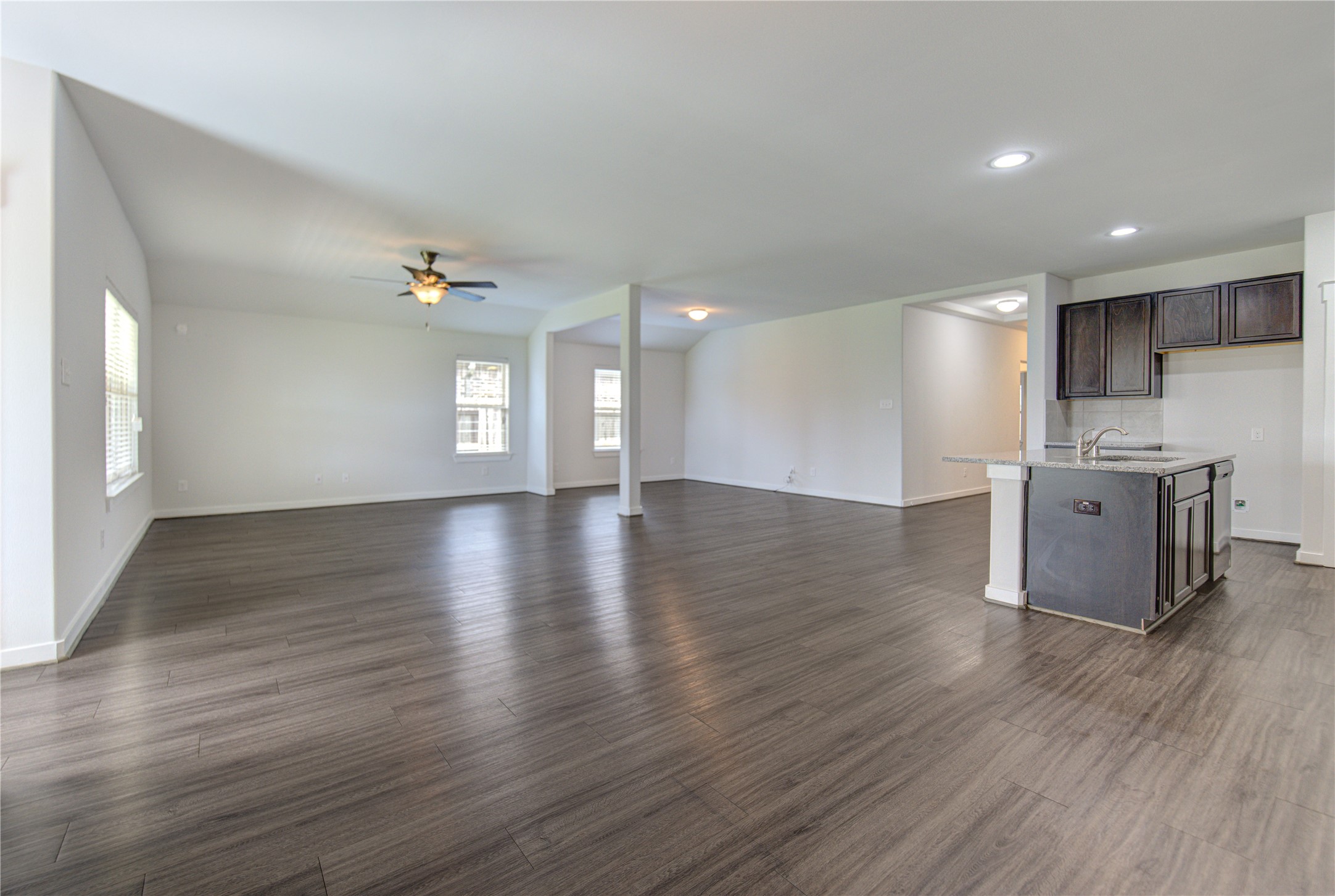 12326 Sabine Point Drive Humble, TX 77346 - Photo 15 of 42 a view of an empty room with wooden floor and a kitchen