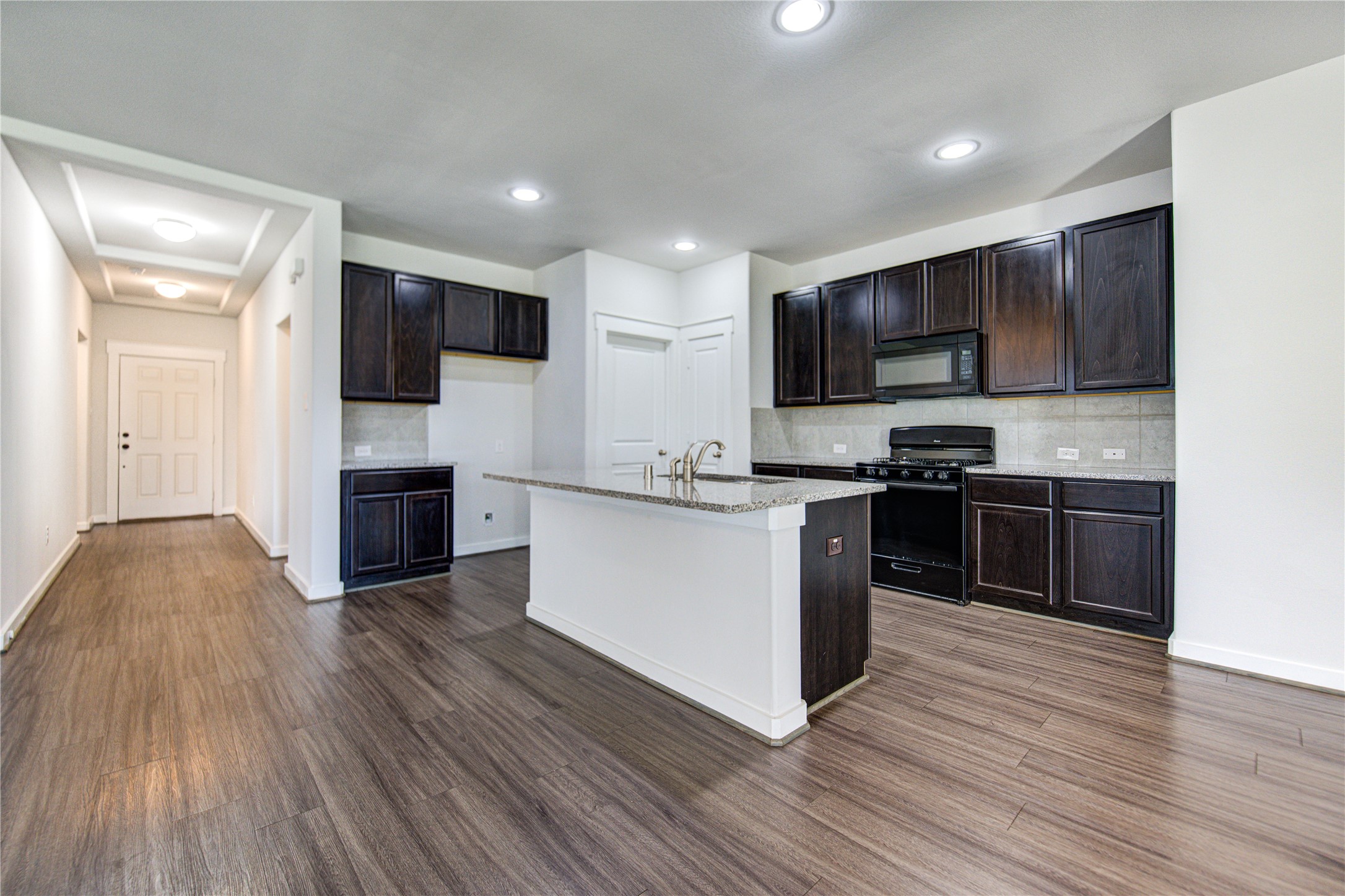 12326 Sabine Point Drive Humble, TX 77346 - Photo 18 of 42 a kitchen with stainless steel appliances kitchen island granite countertop a stove a sink and a refrigerator