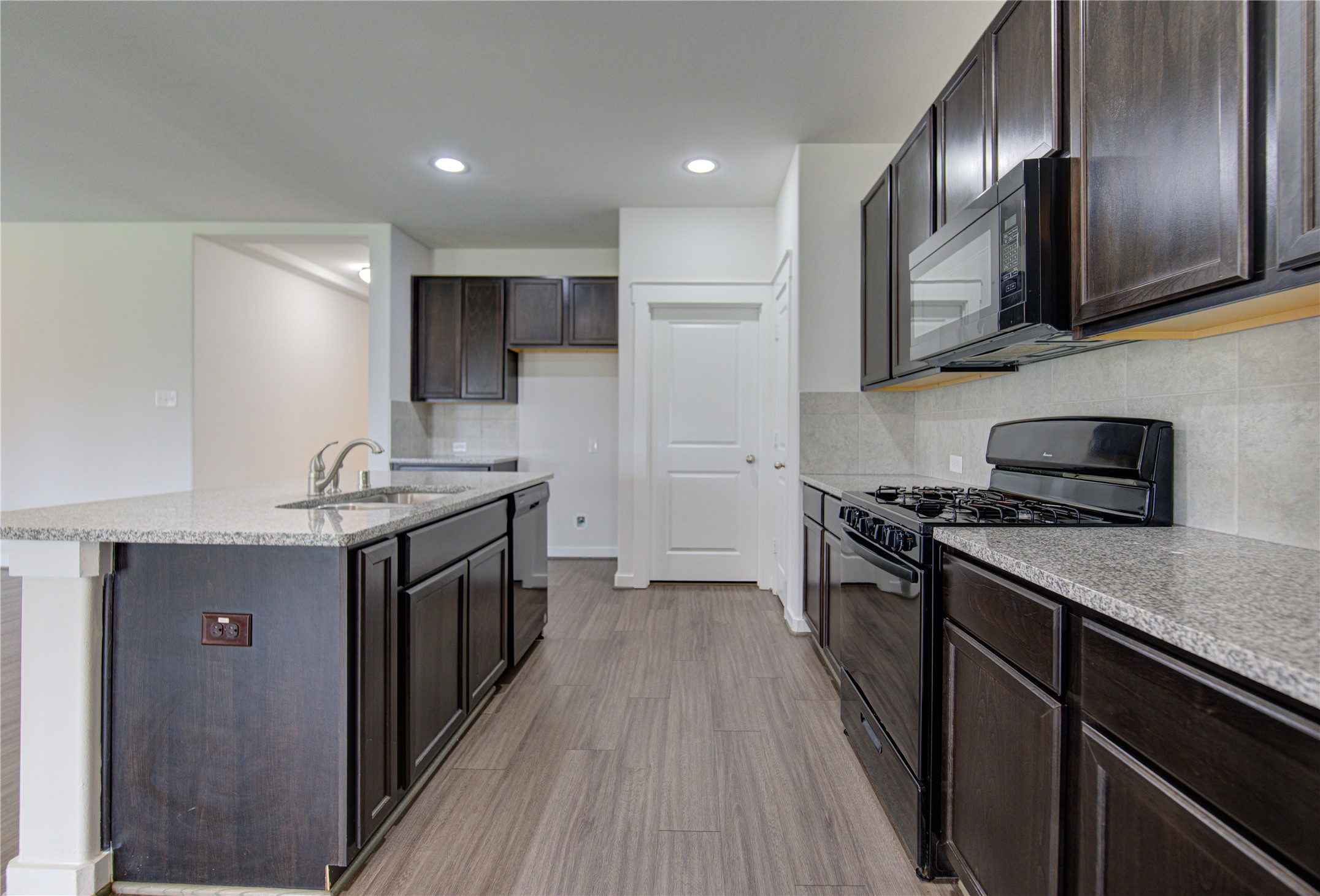 12326 Sabine Point Drive Humble, TX 77346 - Photo 20 of 42 a kitchen with stainless steel appliances granite countertop a stove top oven a sink dishwasher a refrigerator and cabinets with wooden floor