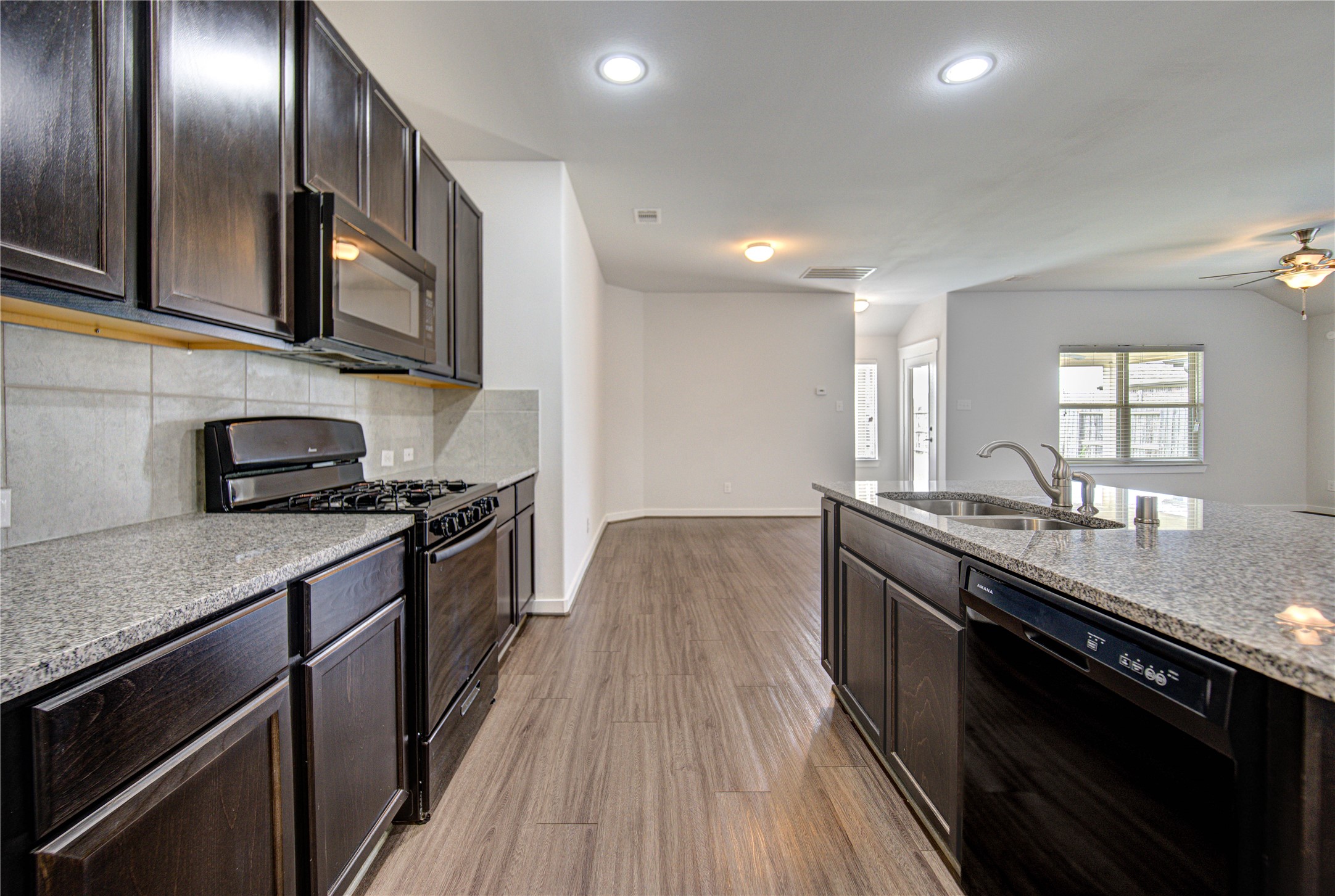 12326 Sabine Point Drive Humble, TX 77346 - Photo 21 of 42 a kitchen with stainless steel appliances granite countertop a sink a stove and a wooden floors
