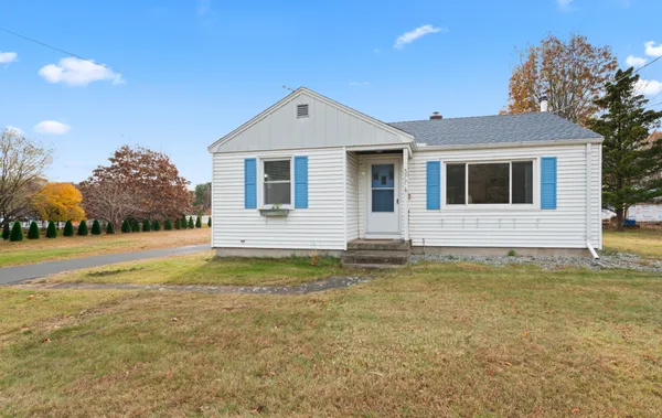 a front view of a house with yard and trees