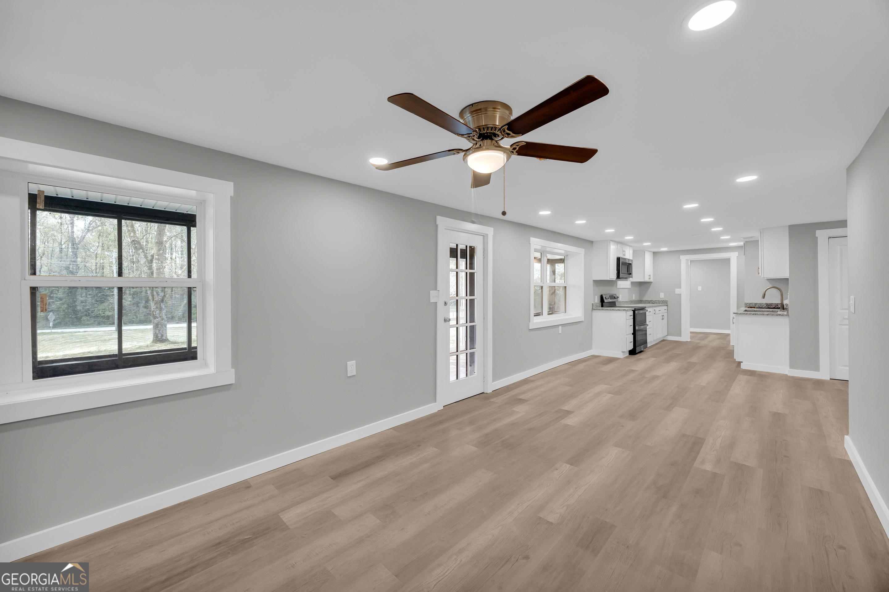 8606 Holly Springs Road Maysville, GA 30558 - Photo 37 of 74 a view of a big room with wooden floor and a ceiling fan