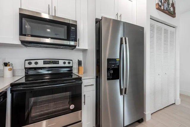 a kitchen with stainless steel appliances a stove microwave and refrigerator