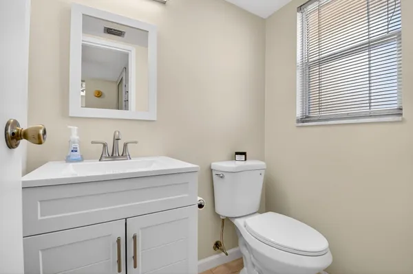 a bedroom with a bed and a lamp on the dresser