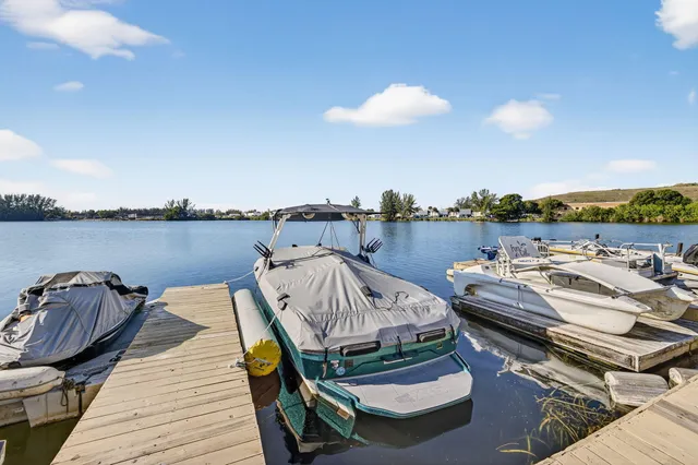 a view of a chairs and table on wooden deck with lake view