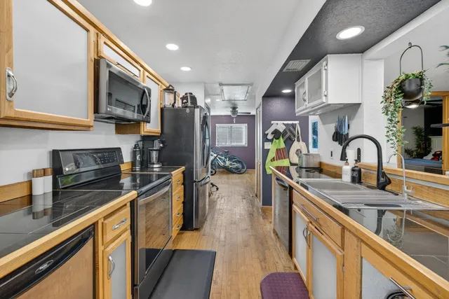 a kitchen with stainless steel appliances a sink a stove top oven a counter space and cabinets