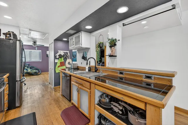 a kitchen that has a sink a stove and a wooden floor