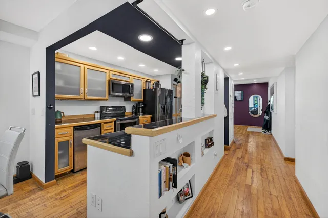 a large white kitchen with stainless steel appliances granite countertop a stove and a sink