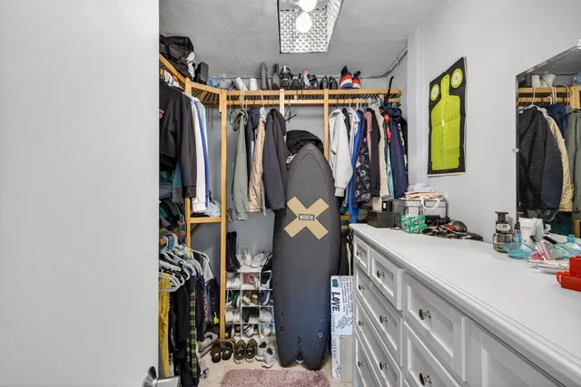 a view of walk in closet with clothes and shoes