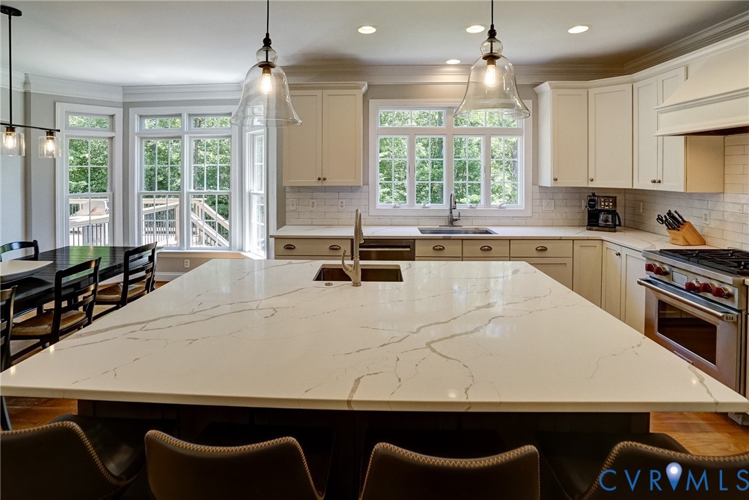 1295 Hermitage Road Manakin-Sabot, VA 23103 - Photo 27 of 55 a large white kitchen with granite countertop a stove a sink a dining table and chairs