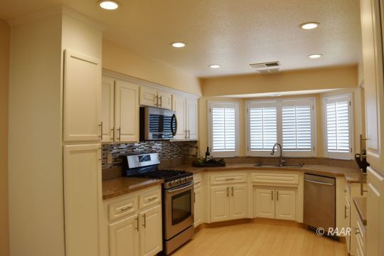 608 South Norma Street Ridgecrest, CA 93555 - Photo 5 of 21 a kitchen with granite countertop a sink and white cabinets