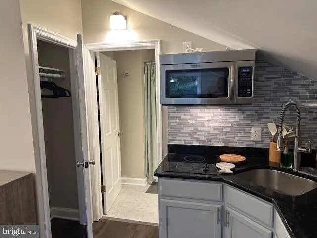a kitchen with a refrigerator and white cabinets