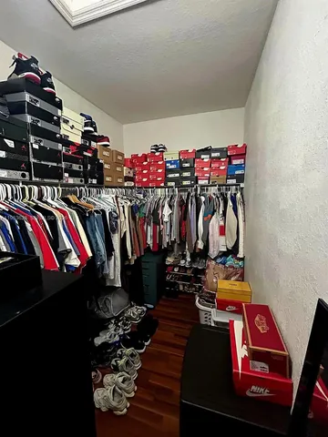 a view of walk in closet with clothes