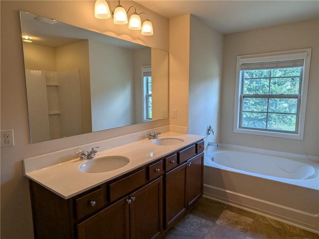 105 Whitney Way Dallas, GA 30157 - Photo 23 of 30 a bathroom with a sink double vanity granite tub and a mirror