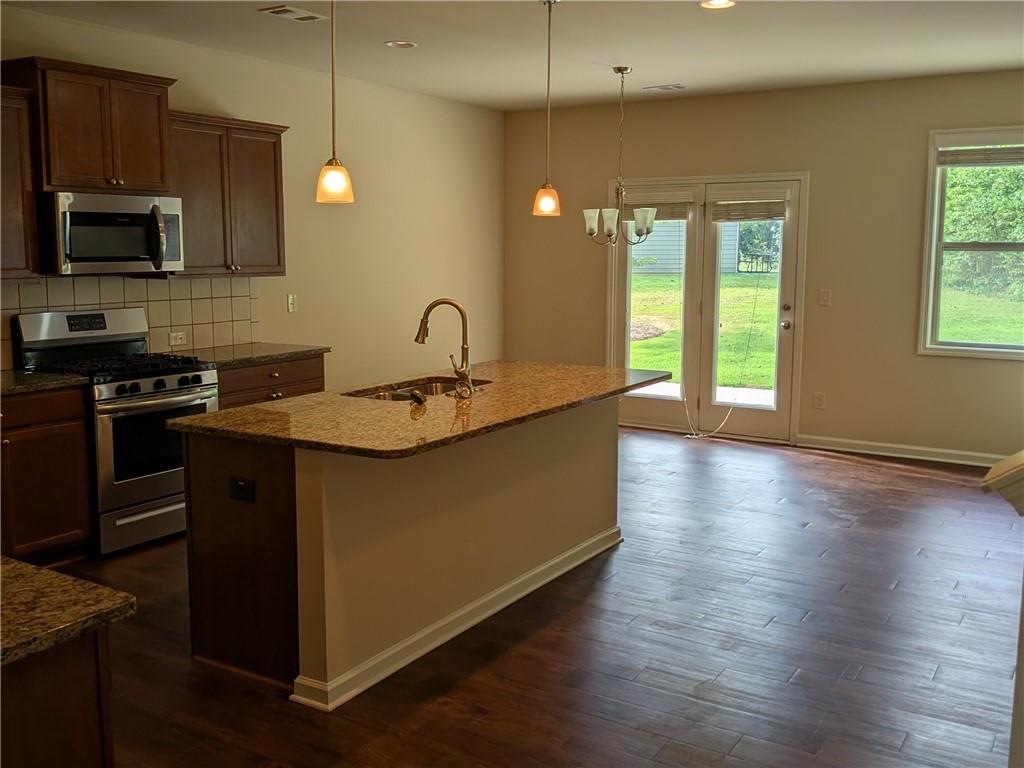 105 Whitney Way Dallas, GA 30157 - Photo 6 of 30 a kitchen with a sink a microwave and wooden floor
