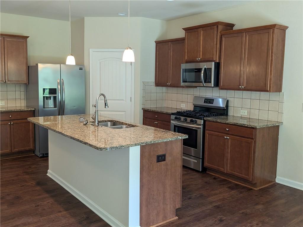 105 Whitney Way Dallas, GA 30157 - Photo 7 of 30 a kitchen with stainless steel appliances granite countertop a sink stove microwave and cabinets