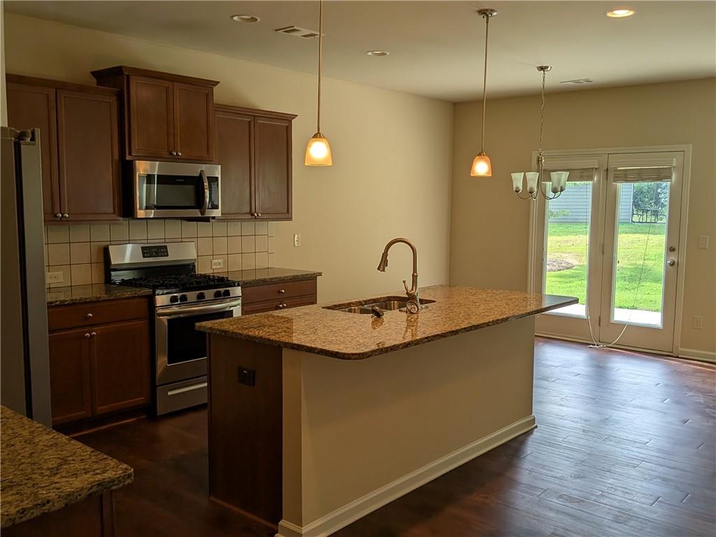 105 Whitney Way Dallas, GA 30157 - Photo 8 of 30 a kitchen with stainless steel appliances granite countertop a sink a stove and a refrigerator