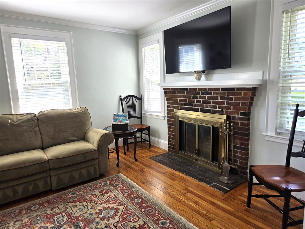 25 Waldeck Road Milton, MA 02186 - Photo 5 of 34 a living room with furniture a flat screen tv and a fireplace