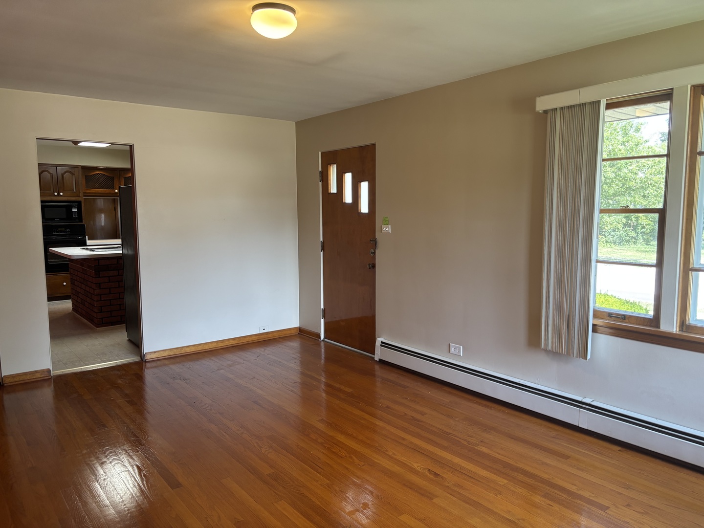 1378 East Street Crete, IL 60417 - Photo 8 of 12 a view of an empty room with wooden floor and a window