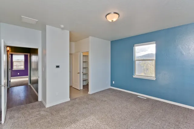 an empty room with windows and closet