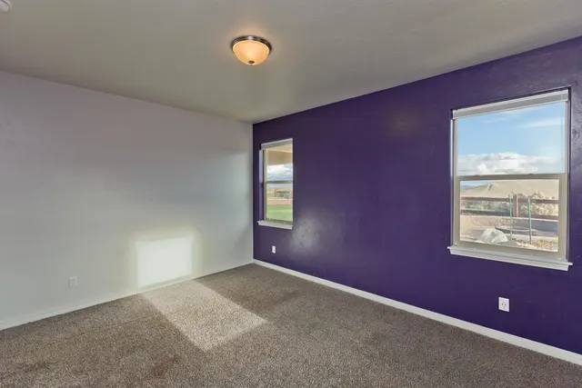 an empty room with windows and mirror