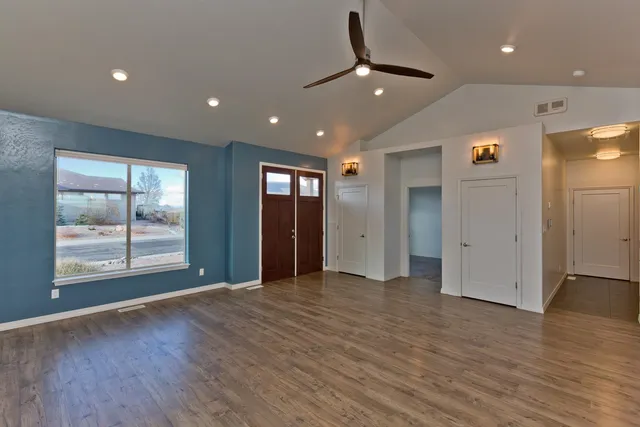 an empty room with wooden floor and windows