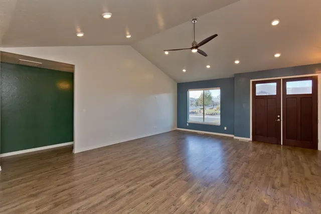 an empty room with wooden floor and windows