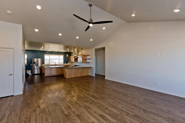 a kitchen with stainless steel appliances granite countertop a sink a stove and a refrigerator