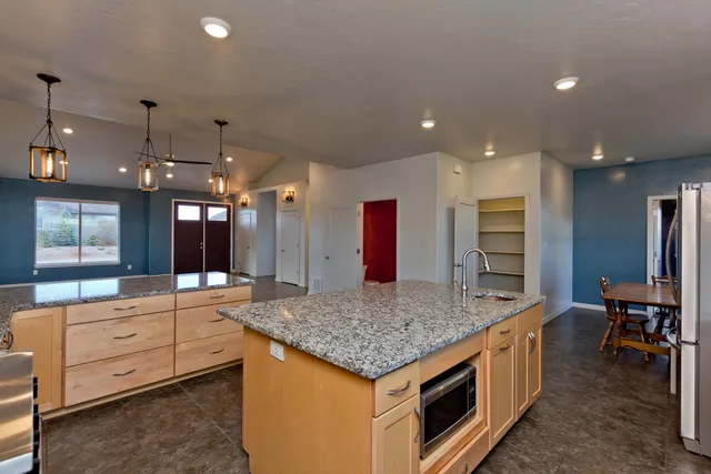 a kitchen with stainless steel appliances granite countertop a sink and a refrigerator
