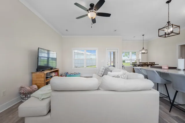 a living room with furniture and a ceiling fan