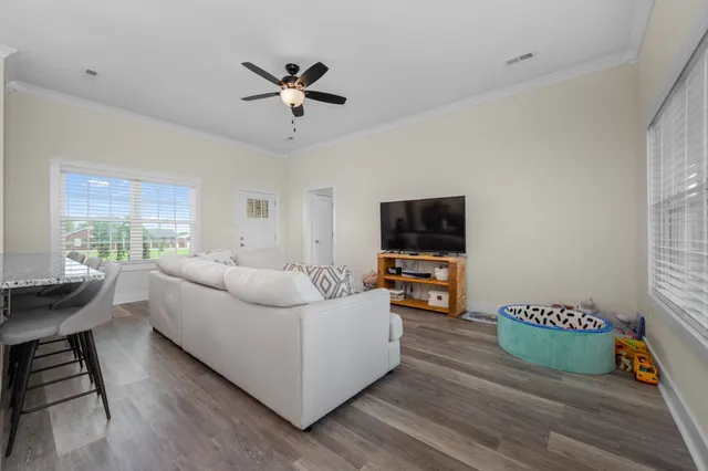 a living room with furniture and a wooden floor