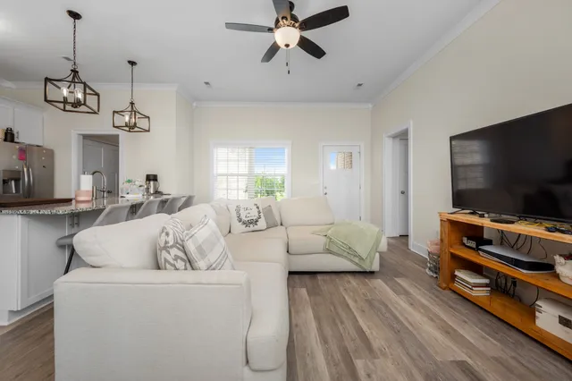 a kitchen with stainless steel appliances granite countertop a sink a stove a dining table and chairs with wooden floor