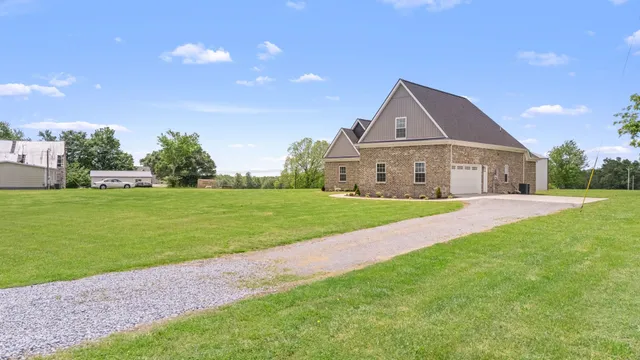 a view of a house with a yard and large tree